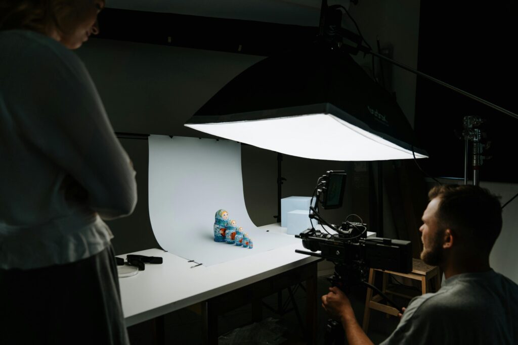 A photographer captures a traditional matryoshka doll in a studio setting.